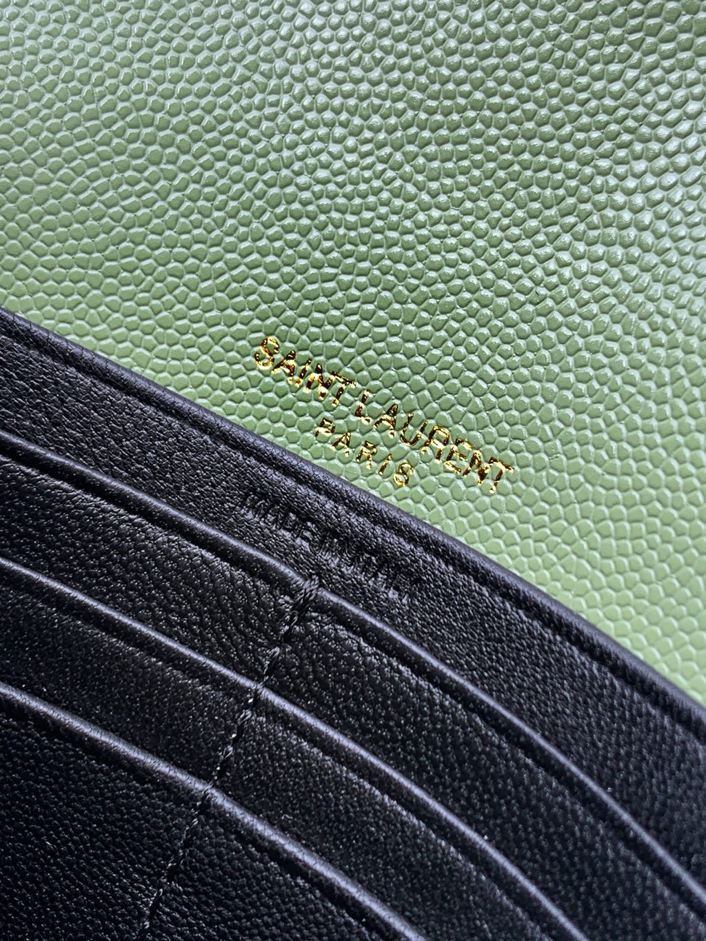 Close-up of green and black YSL bag panels with stitching and hardware