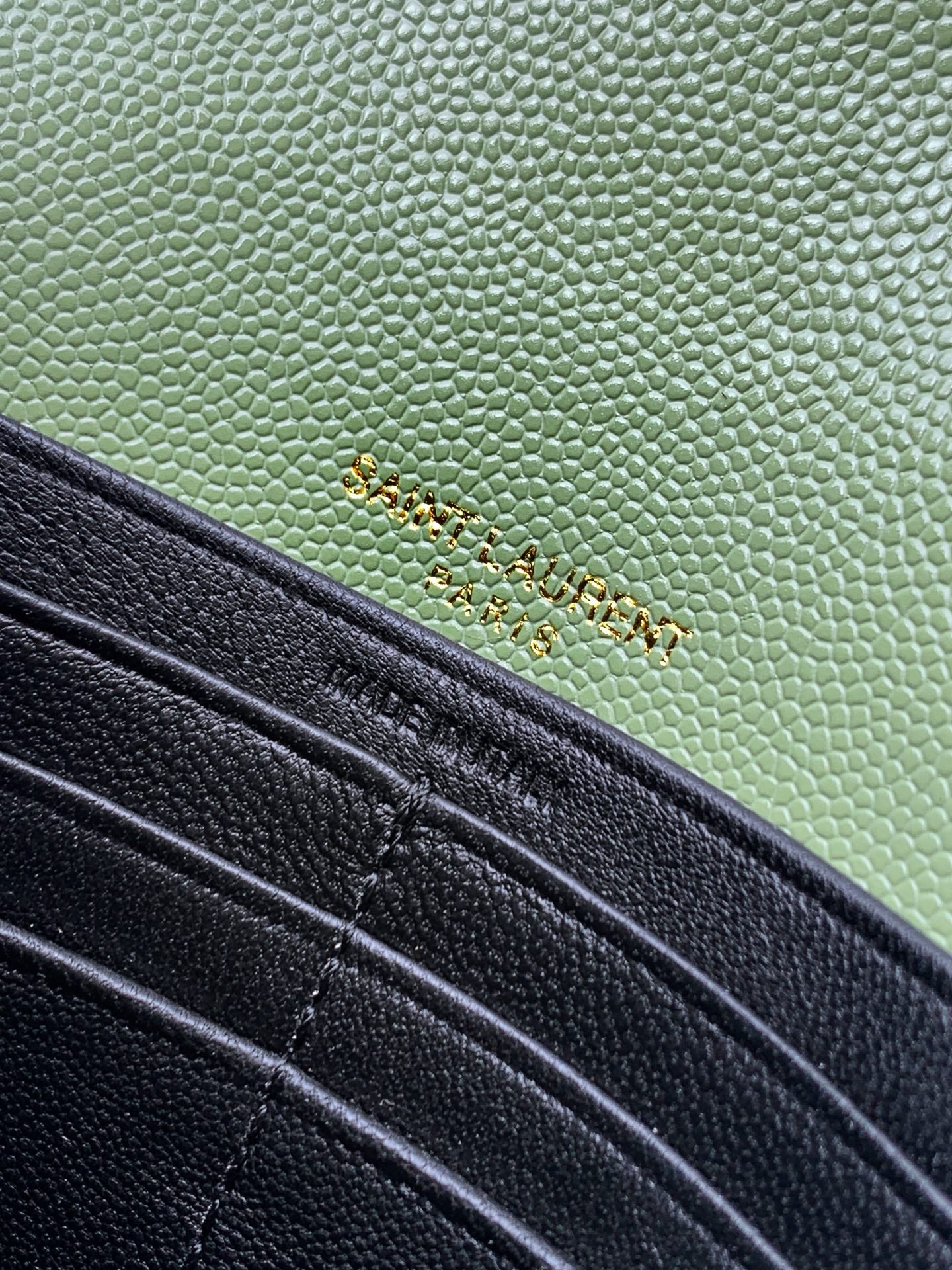 Close-up of green and black YSL bag panels with stitching and hardware