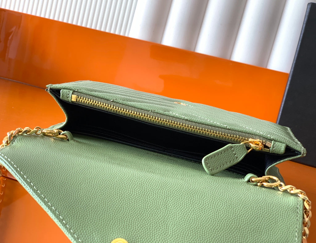 Green YSL bag opened to show black interior and gold zipper