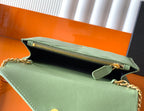 Green YSL bag opened to show black interior and gold zipper