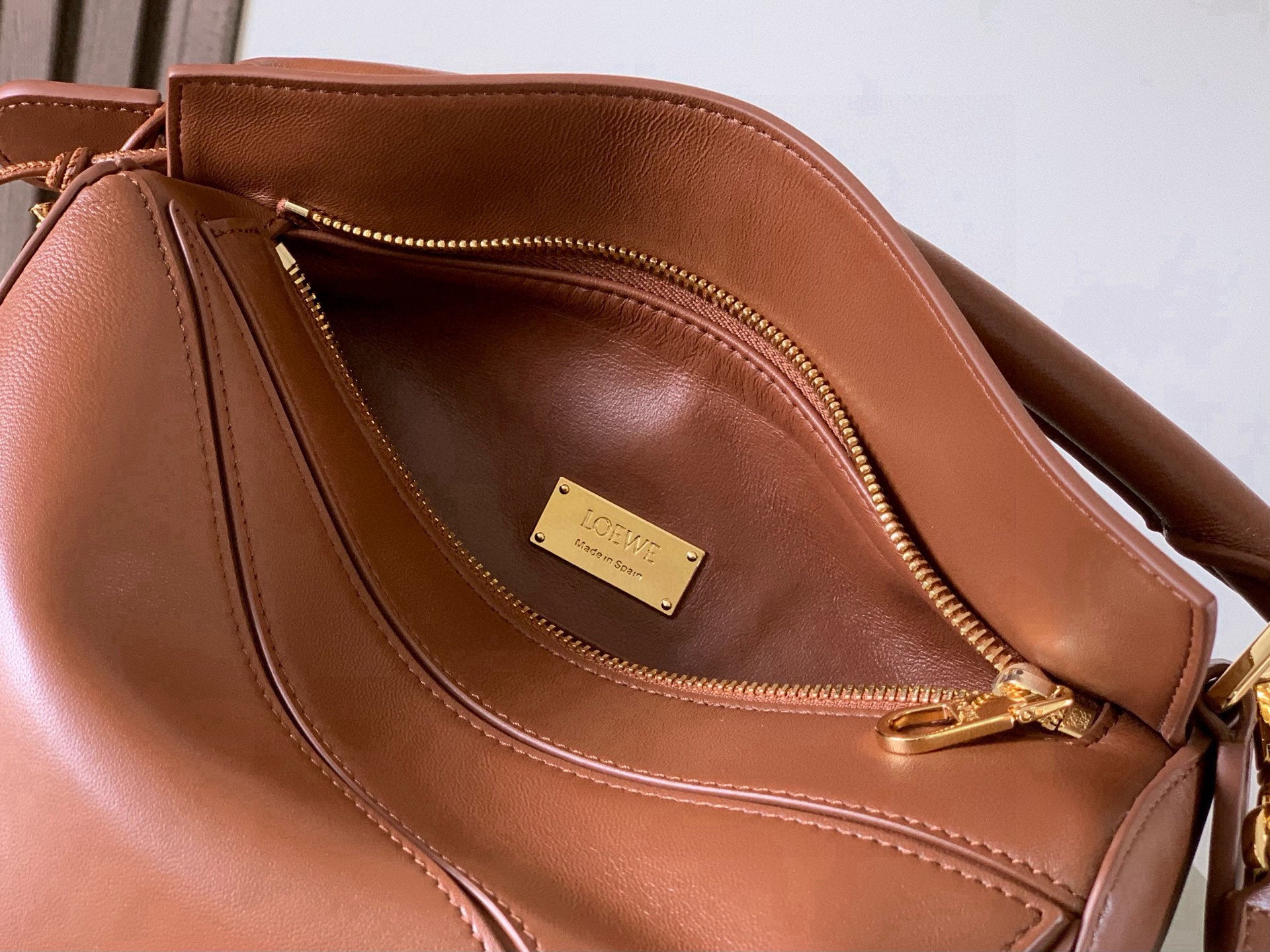 Loewe brown leather bag interior with top zipper and divided pocket