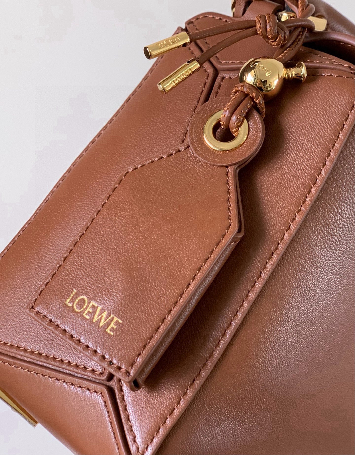 Loewe brown leather bag close-up with zipper pull and "LOEWE" label