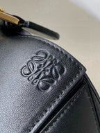 Black leather bag exterior with embossed logo pattern