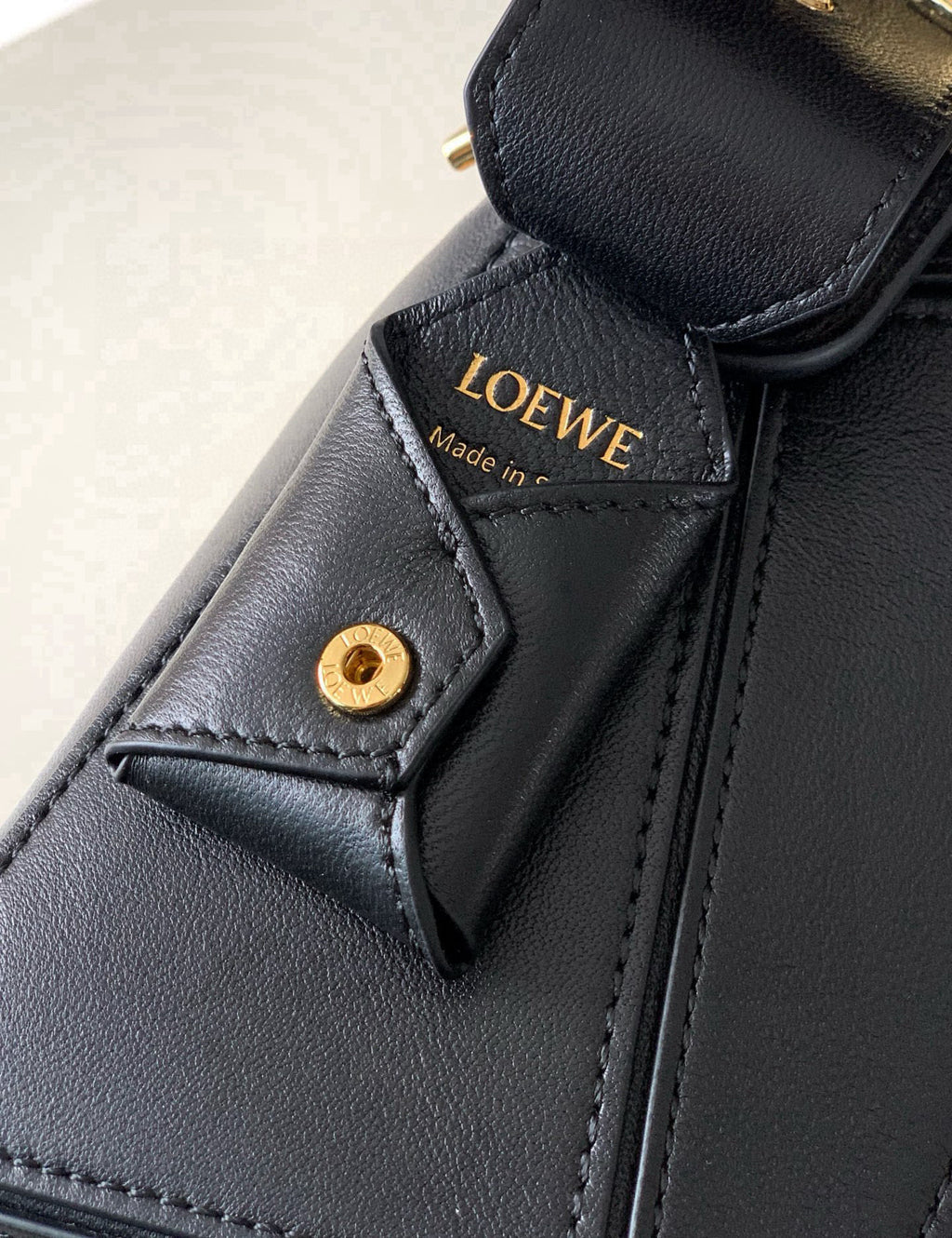 Loewe black leather bag detail with stitched leather tab and small gold snap