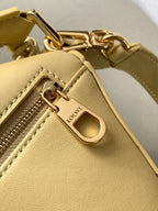 Loewe light yellow leather bag close-up with gold zipper pull and logo plate