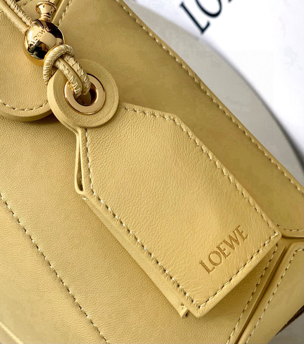 Loewe light yellow leather bag close-up with O-ring strap attachment and side stitching