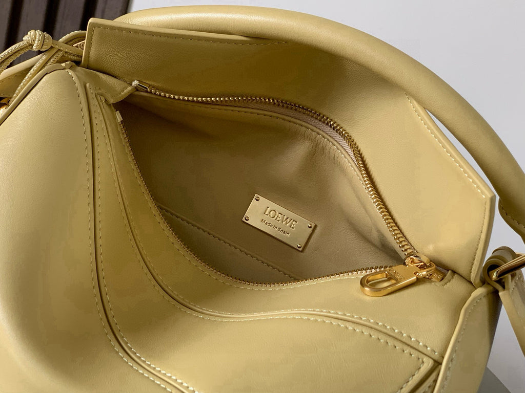 Loewe light yellow leather bag interior view with gold zip and logo patch