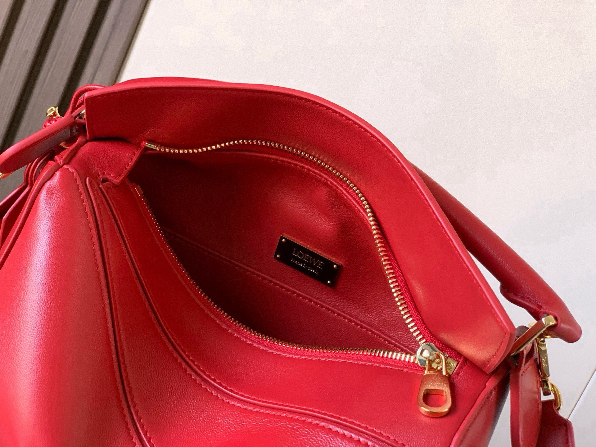 Red leather bag interior with zip top and black logo label