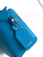 Blue leather bag top detail with metal ring, clasp, and stitched panel