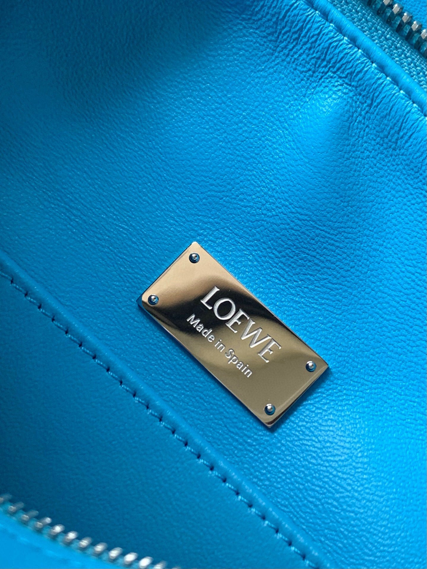 Blue leather bag with Loewe metal logo plate and contrast stitching