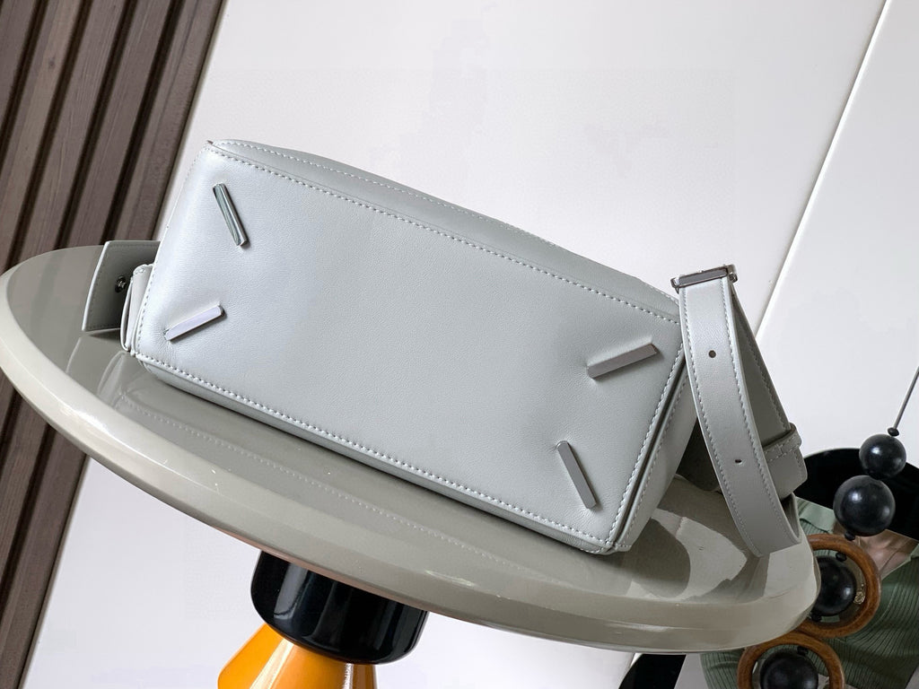 Light gray leather clutch-style bag with top flap and side zipper closure