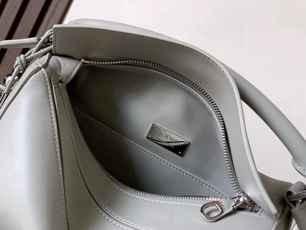 Light gray leather mini handbag interior with zipper pocket and brand patch label