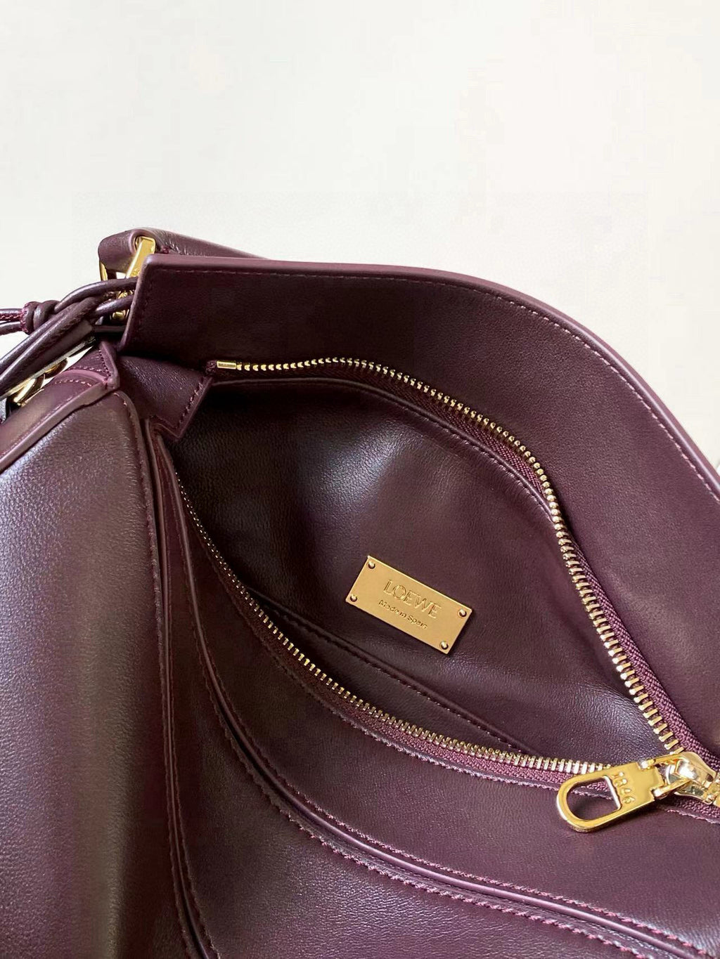Loewe burgundy leather bag interior view with gold-tone hardware and zip pocket