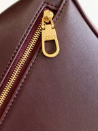 Loewe maroon leather bag zipper pull with gold ring and LOEWE logo on zipper tab