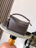 Brown leather shoulder bag with top handle and adjustable strap