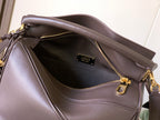 Leather bag interior view with zip pocket and gold-tone zipper pulls, dark brown