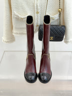 Back view of burgundy knee-high boots with black heels and gold chain trim