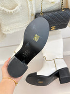 White leather knee boot outsole with black tread and embossed logos in hand