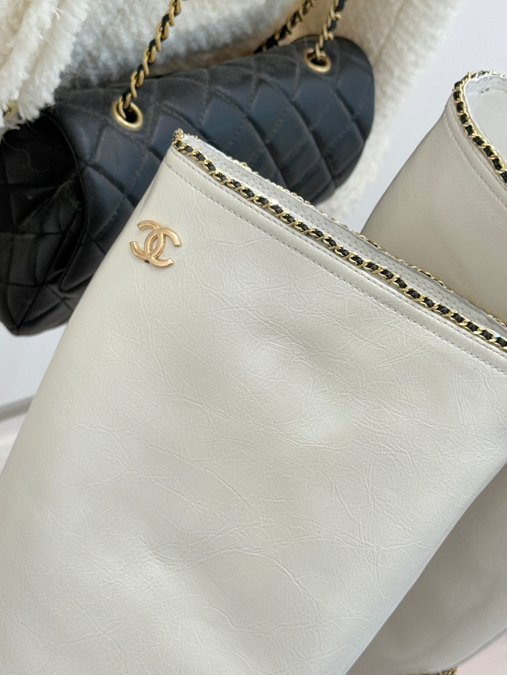 White leather clutch purse with gold chain strap and Chanel emblem