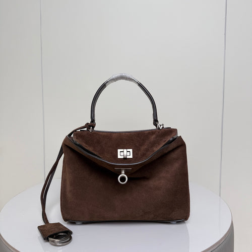 Brown suede handbag with top handles and front flap clasp.