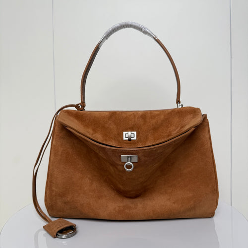 Tan suede top-handle handbag with flap clasp and metal trim, plus shoulder strap