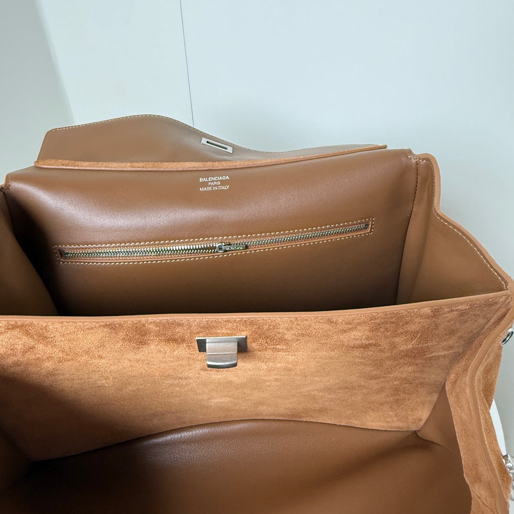 Tan suede handbag interior with brown lining, center latch, and zipper track