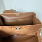Tan suede handbag interior with brown lining, center latch, and zipper track