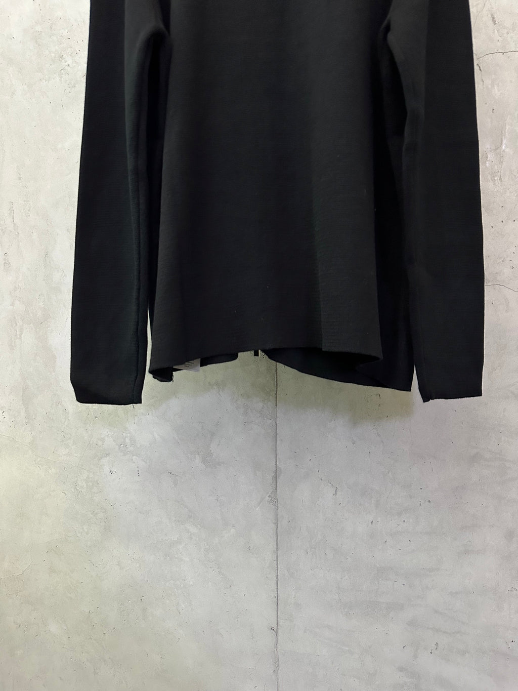 Black zip-up jacket, lower back view, long sleeves