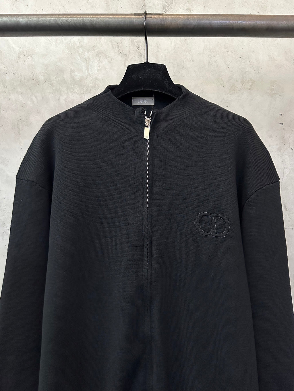 Black zip-up jacket with chest logo and full zipper