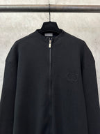 Black zip-up jacket with chest logo and full zipper
