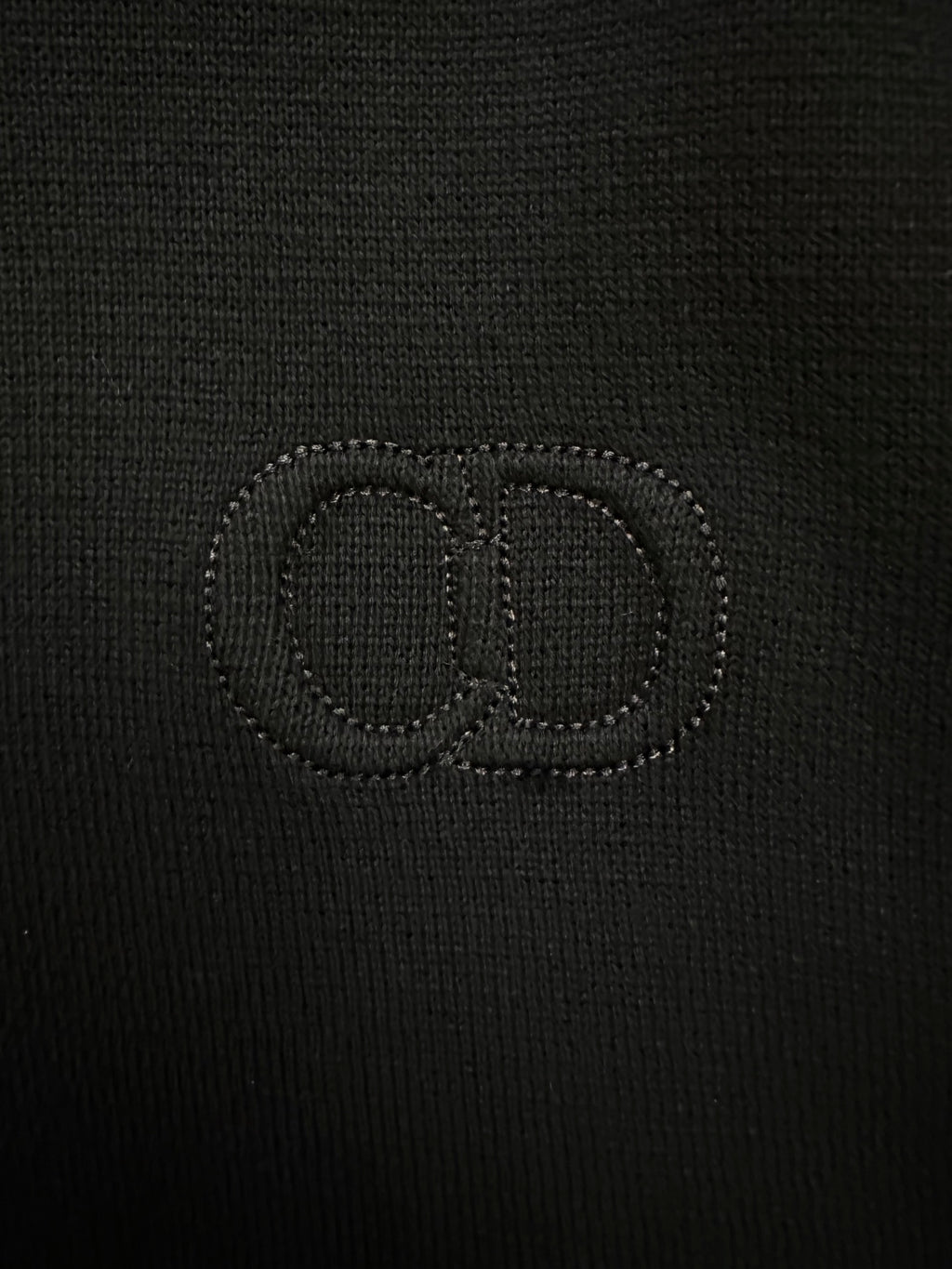 Black knit jacket with stitched logo on the chest