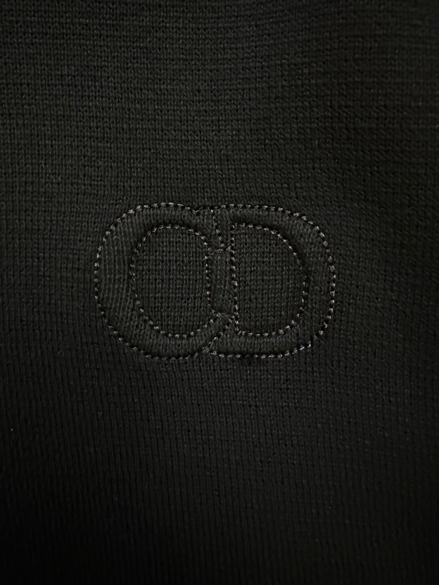 Black knit jacket with stitched logo on the chest