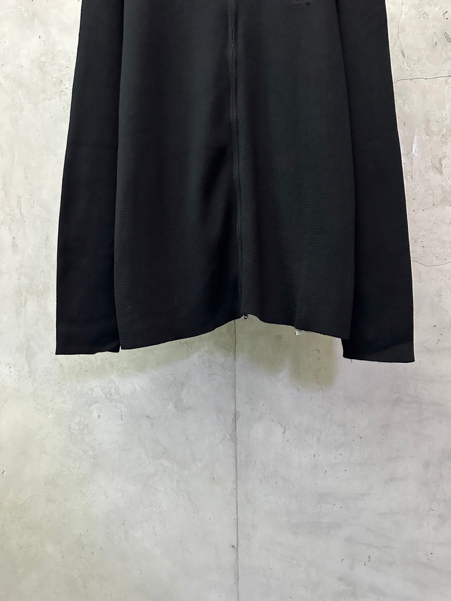 Black zip-up jacket hem and long sleeves with front zipper opening