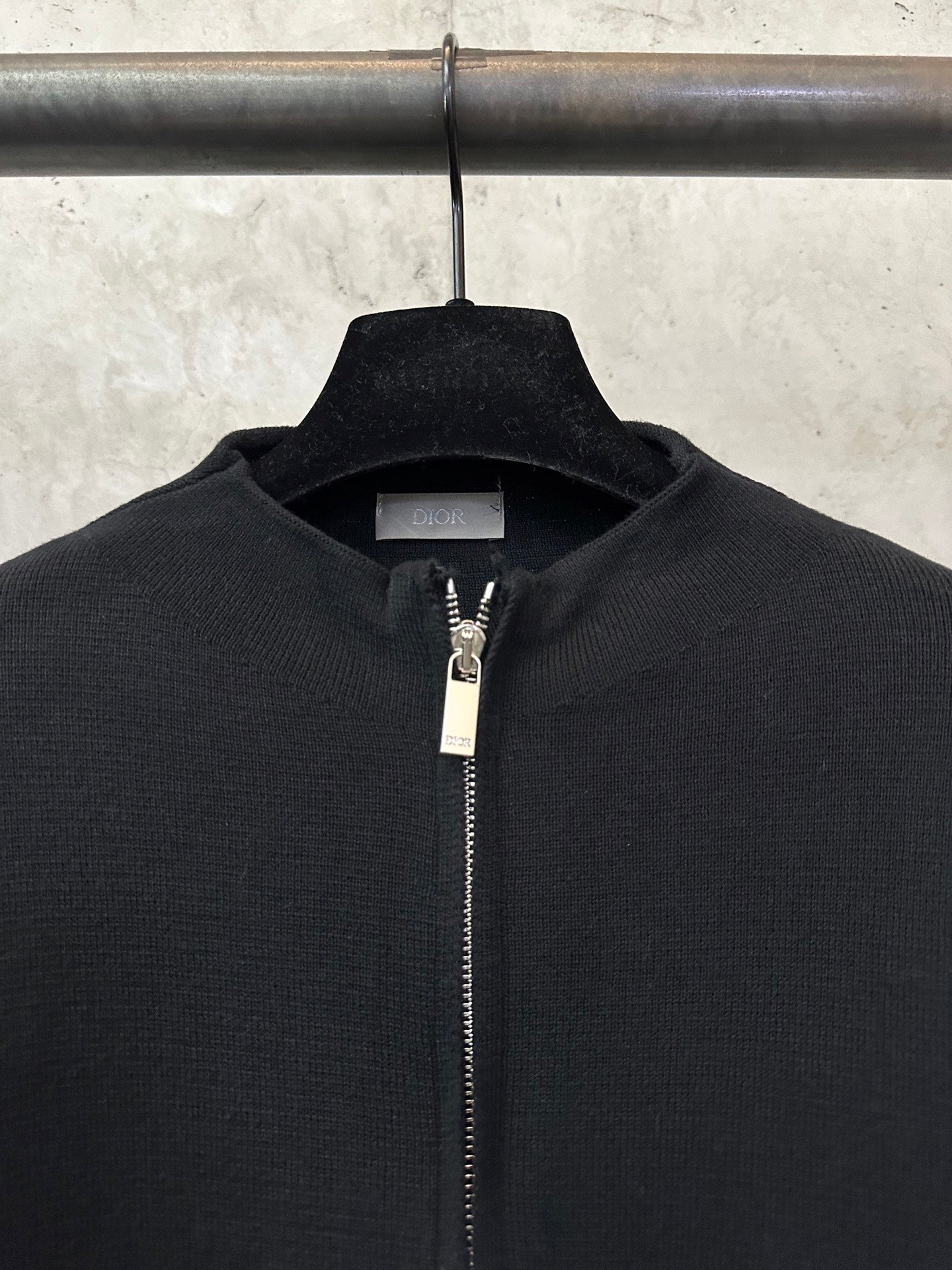 Black knit zip-up jacket with metal zipper and stand collar