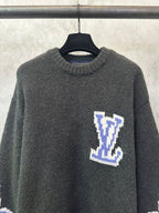 Dark charcoal knit sweater with blue-and-white Louis Vuitton-style diamond logo on chest