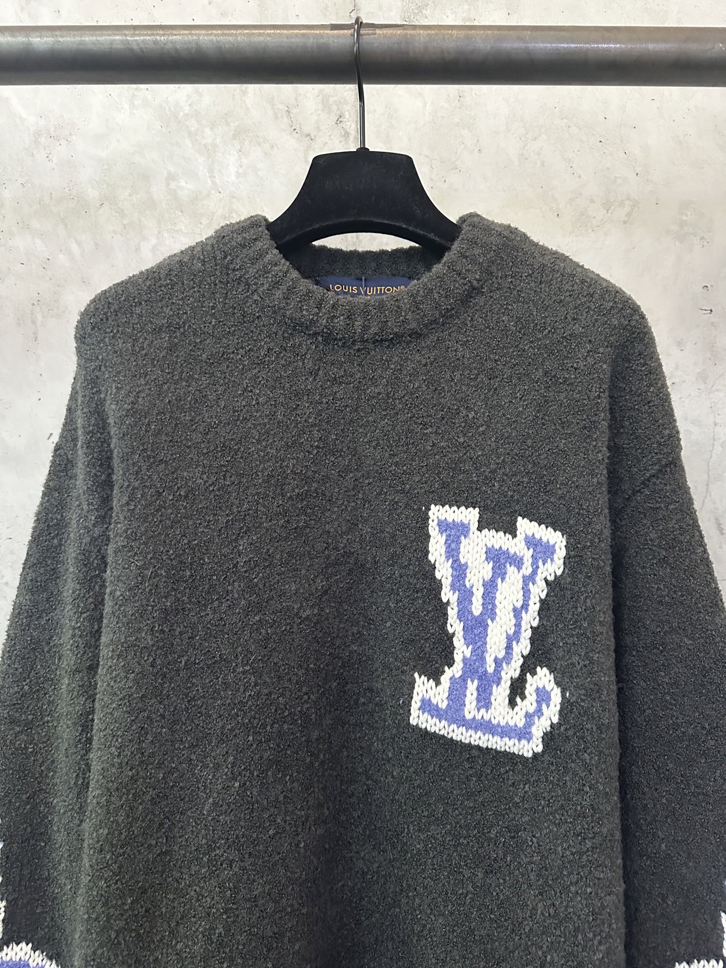 Dark charcoal knit sweater with blue-and-white Louis Vuitton-style diamond logo on chest