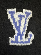 Dark charcoal knit sweater close-up of blue-and-white Louis Vuitton-style diamond logo