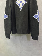 Dark charcoal knit sweater back view with blue-and-white monogram diamond and side motifs
