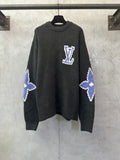 Dark charcoal knit sweater with blue-and-white Louis Vuitton-style monogram on chest