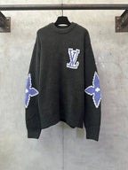 Dark charcoal knit sweater with blue-and-white Louis Vuitton-style monogram on chest