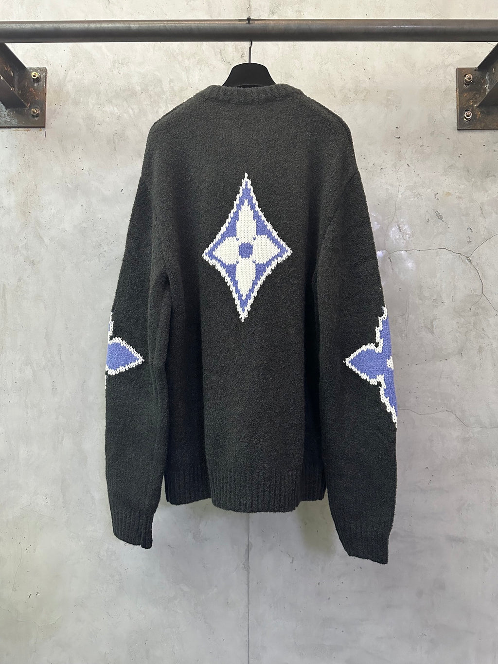 Dark charcoal knit sweater, back view, with large blue-and-white diamond monogram
