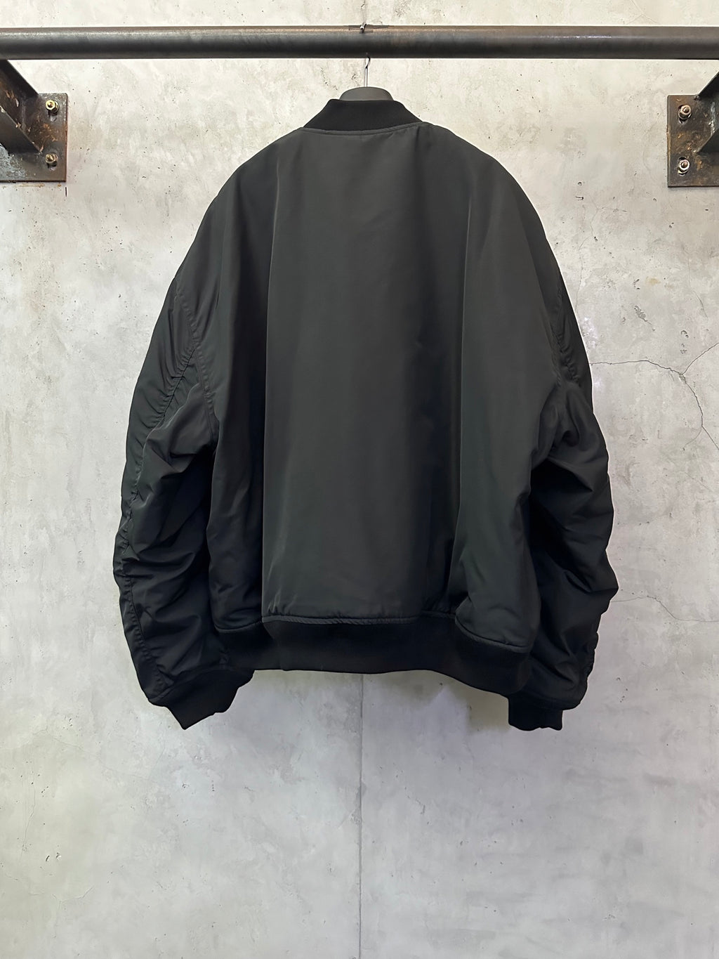 Black bomber jacket back view with ribbed hem and ribbed cuffs