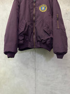 Purple zip bomber jacket with crest logo patch, side pockets, and ribbed cuffs