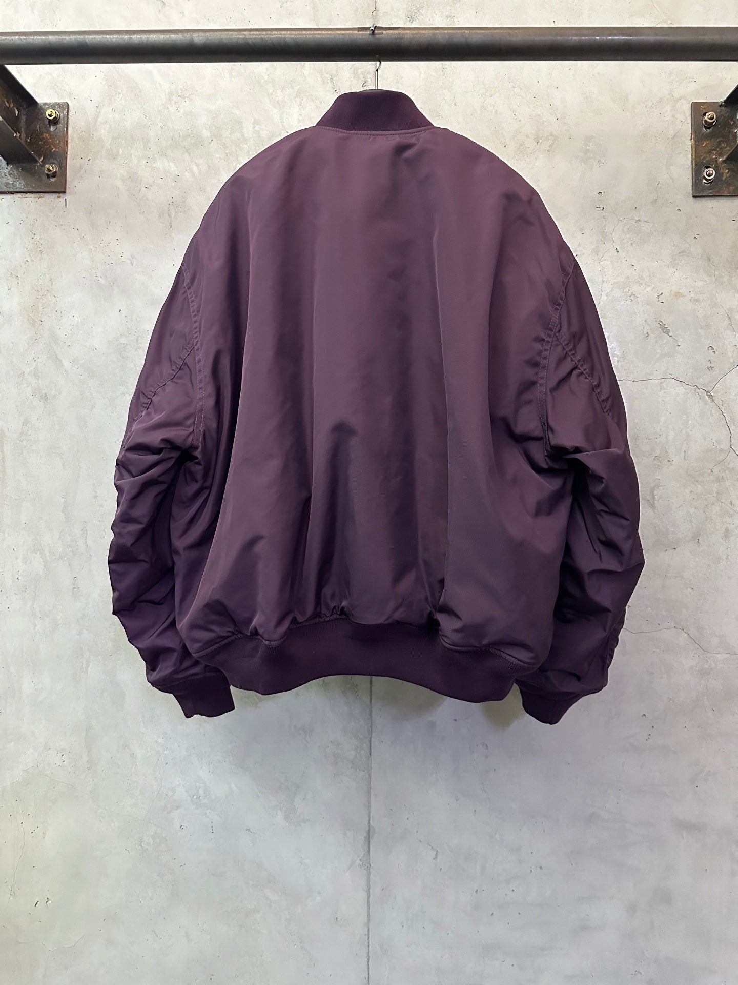 Purple bomber jacket back view with ribbed cuffs, hem, and relaxed shoulder shape