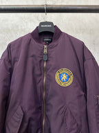 Purple bomber jacket with gold zipper and chest crest logo patch