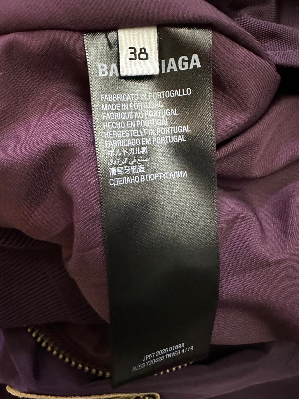 Inside size 38 fabric label on purple bomber jacket, made in Portugal