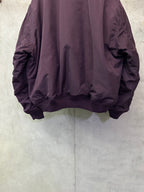 Purple bomber jacket back with ribbed hem and gathered fabric at sleeves