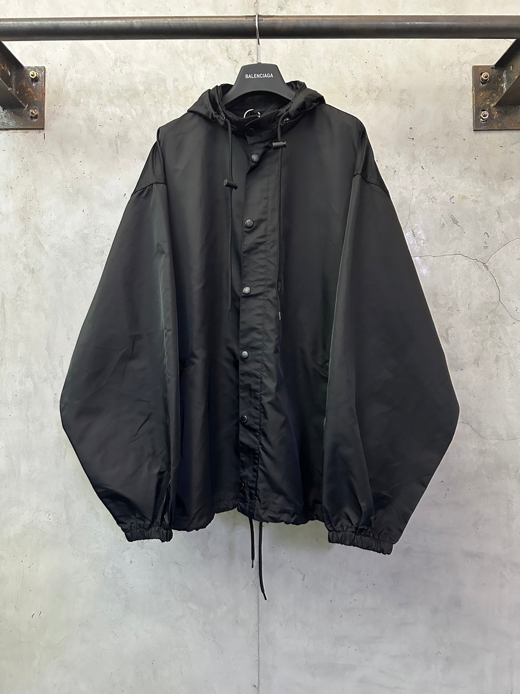Black hooded jacket with button front and drawstring hem, long sleeves