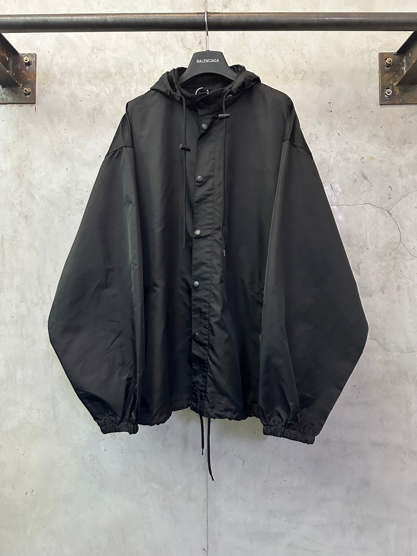 Black hooded jacket with button front and drawstring hem, long sleeves
