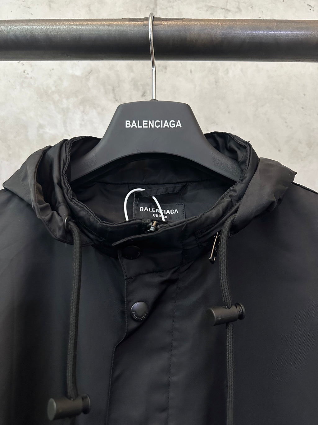 Black jacket neckline with hood, button placket, and drawcord toggles